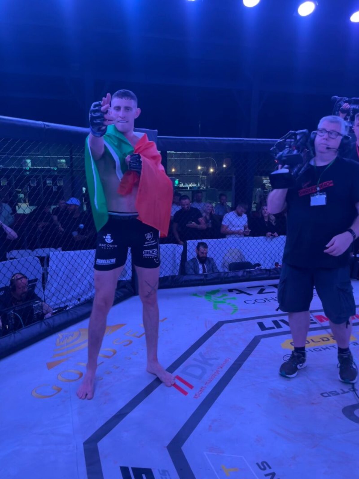 Eoin Sheridan celebrating with the Irish flag in the cage